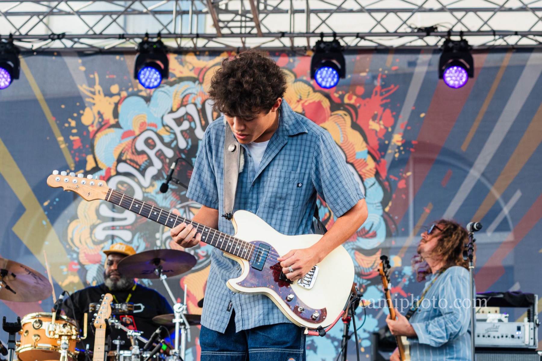 Dylan Miles playing his left-handed guitar on stage at NOLA Funk Fest